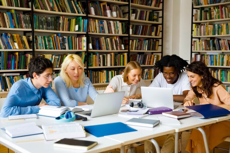 estudiante en laptop con libros de derecho